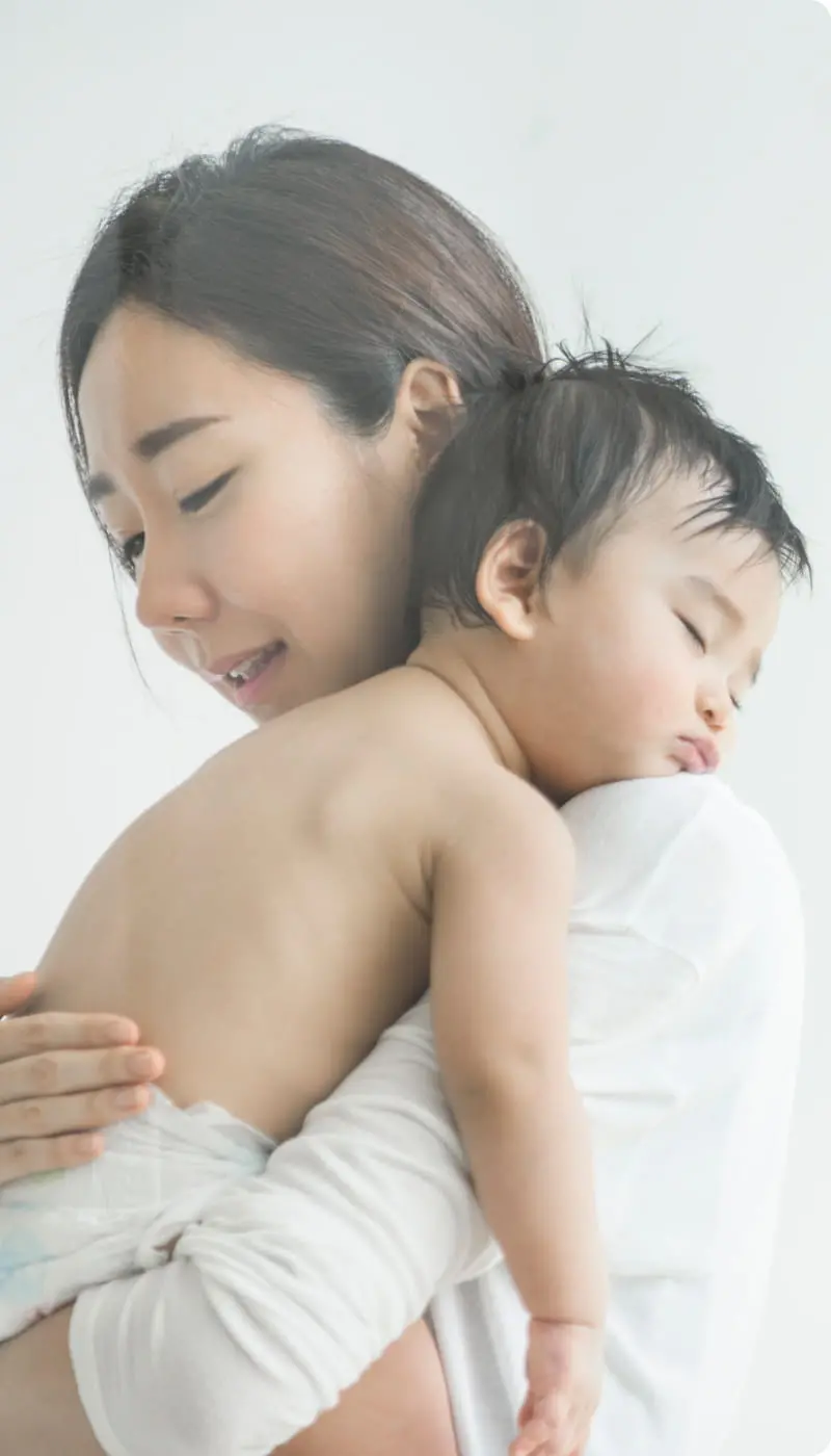 眠る赤ちゃんを抱く女性